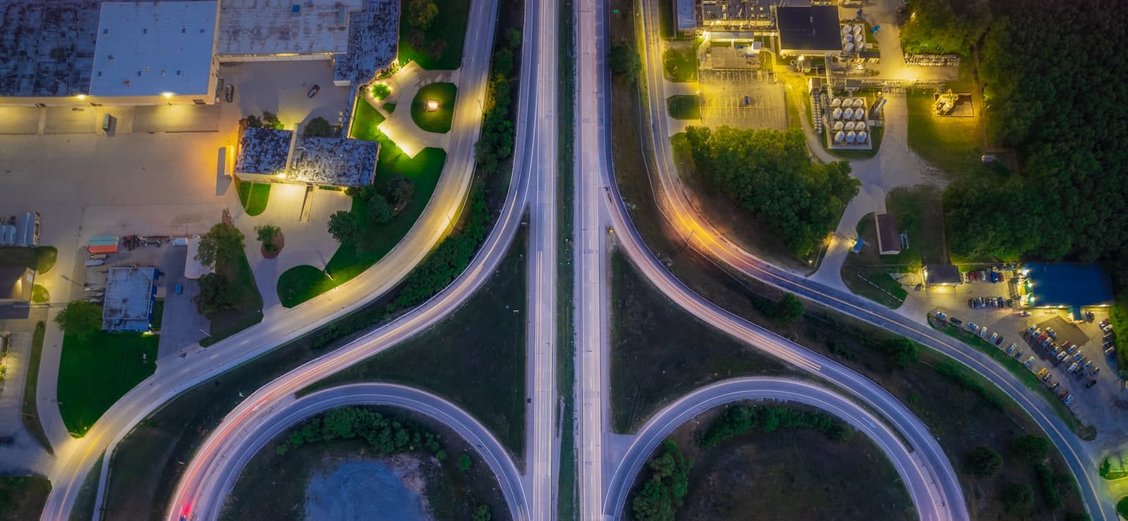 Aerial view of a highway interchange at night with light trails